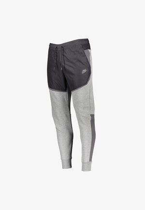 Graue und schwarze Nike-Jogginghose mit Kordelzugbund, elastischen Bündchen, Seitentaschen und reflektierendem Logo am oberen Oberschenkel.