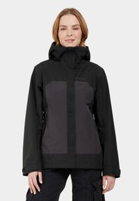 Black waterproof jacket with a gray panel, zippered pockets, adjustable hood, and long sleeves. Soft texture and sleek design.