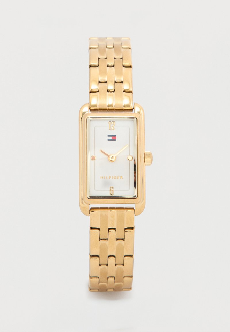Gold-tone rectangular watch with a metal link bracelet, white face, gold hour markers, and a small logo. Simple design with a classic look.