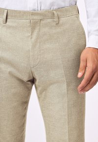 Leinenmischungshosen in hellbeige, mit einer maßgeschneiderten Passform, flacher Vorderseite und seitlichen Taschen, mit einem glatten, strukturierten Finish.