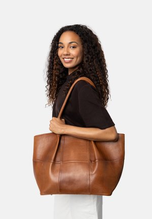 Borsa a tote in vera pelle marrone con una finitura morbida, ampio interno e pannelli cuciti. Presenta spallacci robusti e un design spazioso.