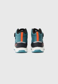 Teal og svarte høyde sneakers med oransje detaljer, teksturert stoff og en rund lukkemekanisme ved ankelen for sikker passform.