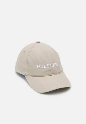 Beżowa bawełniana czapka baseballowa z zakrzywionym daszkiem i białym wyszywanym napisem "HILFIGER" na środku z przodu.