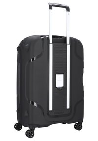 Valigia rigida nera con texture liscia, dettagli metallici argentati, manico retrattile, quattro ruote girevoli e lucchetto a combinazione frontale.