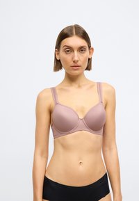 Hnedá bezšvová podprsenka s kostícami, nastaviteľnými ramienkami a hladkým povrchom, s guľatým tvarom a jemnými švami.