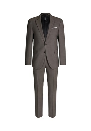 Grauer Anzug aus strukturiertem Stoff, mit einem Zweiknopf-Sakko mit Revers und schmal geschnittenen Hosen, weißes Einstecktuch als Detail.
