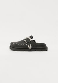 Black leather clog featuring a thick, textured sole, silver decorative buckle, and studded accents along the side.