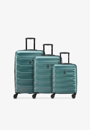Trois valises rigides bleu sarcelle avec quatre roues et poignées télescopiques noires en petites, moyennes et grandes tailles.