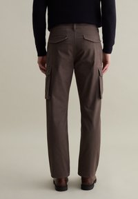 Braune Cargo-Hosen mit Seitentaschen und geradem Schnitt. Hergestellt aus strapazierfähigem Stoff, mit glatter Textur und Rückentaschen-Details.