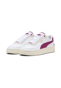 Zapatillas blancas con una franja púrpura de Puma, parte superior de cuero, suela de goma, puntera perforada y cuello acolchado para mayor comodidad.