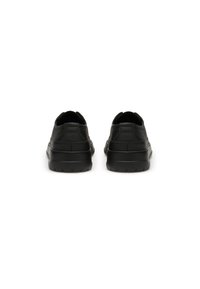 Baskets en cuir noir avec une surface texturée, un dos arrondi et une semelle rembourrée. Présente un design minimaliste et une silhouette profil bas.