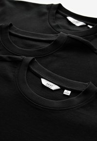 Sorte bomulds T-shirts med rund hals og korte ærmer. Labels synlige; størrelser og mærket "NEXT" trykt indeni kraven.