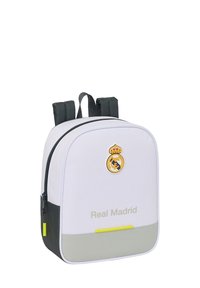 Zaino bianco con spallacci neri, logo del Real Madrid e testo sul fronte, tirazip giallo e pannello inferiore grigio.