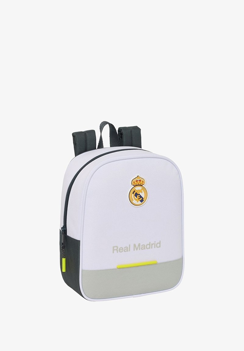 Biały plecak z czarnymi paskami, logo Real Madryd i tekst na przedzie, żółte uchwyty suwaków oraz szara dolna panel.