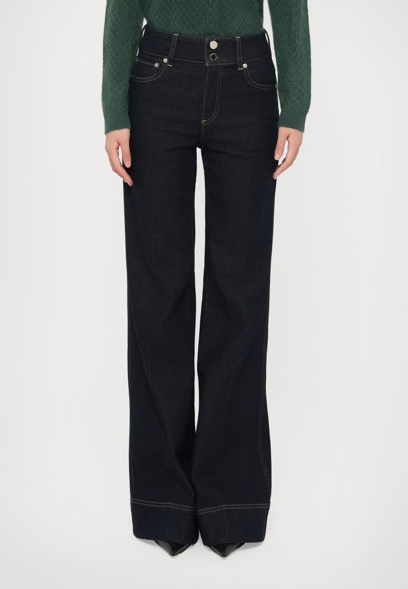 High-waisted, dark denim jeans with a wide-leg design, featuring silver hardware, front pockets, and contrast stitching along the seams.