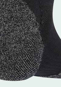 Black and gray knitted sock featuring a textured pattern on the heel, smooth upper, and reinforced toe for durability.