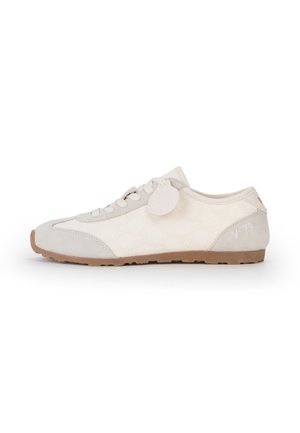 Sneaker beige chiaro low-top con lacci bianchi, suola in gomma, patch in camoscio sulla punta e sul tallone, e una piccola etichetta con il marchio vicino al tallone.