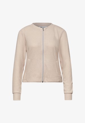 Chaqueta beige claro de manga larga con cremallera, cuello redondo y textura sutil, con dos bolsillos laterales y puños de canalé.