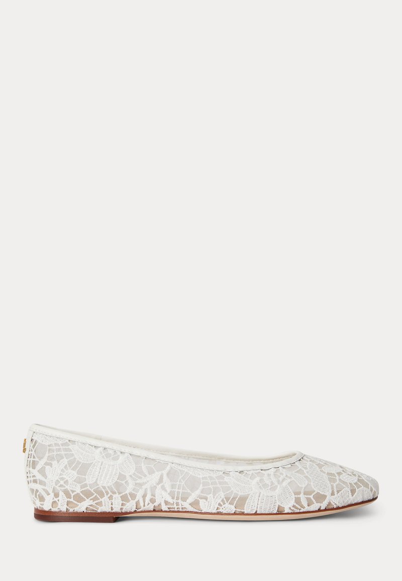 Chaussure plate ballerine en dentelle blanche avec motif floral et fine semelle marron sur fond gris clair uni.
