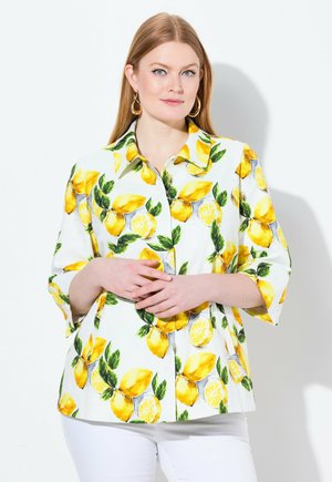 Weiße Bluse mit Knopfleiste, die ein lebhaftes Zitronenmuster mit grünen Blättern und gelben Akzenten präsentiert. Sie hat Dreiviertelärmel und ein lässiges Schnittdesign.