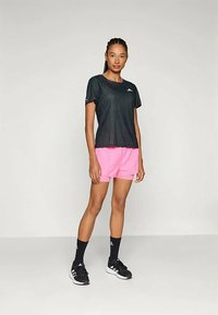 Must keha lühikeste varrukatega must sportlik pluus ribakonstruktsiooniga, millega on kombineeritud erksad roosad lühikesed püksid. Mustad spordijalanõud ja sokid täiendavad komplekti.