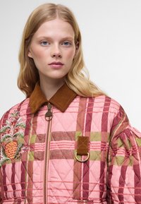 Κουβερτίνα bomber σε καρό σχέδια σε ροζ, καφέ και πράσινο. Διαθέτει γιακά από καπιτονέ ύφασμα, κεντητό σχέδιο ανανά και χρυσό φερμουάρ.