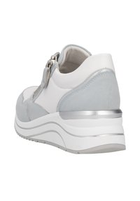 Weiße und hellblaue Sneaker mit einer strukturierten Wildlederrückseite, metallic Akzenten und einer klobigen Sohle mit geschwungenen Linien. Reißverschluss an der Seite.