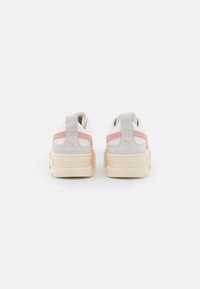 Sneakers bianchi e grigi con dettagli rosa, pannelli in suede testurizzati e suola cremosa spessa. Presentano un linguetta sul tallone.