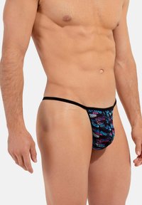 Herren-Tanga aus dehnbarem Stoff. Mit einem schwarzen Bund und einem lebhaften, mehrfarbigen abstrakten Muster. Leicht und mit glatter Textur.