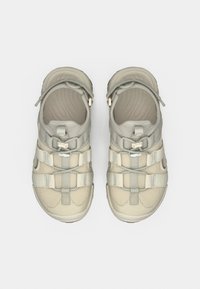 Αθλητικά σανδάλια σε ανοιχτό μπεζ χρώμα με υφασμάτινο πλέγμα στο πάνω μέρος, ρυθμιζόμενα λουράκια και αναπαυτική σόλα. Διαθέτουν ανοίγματα για αερισμό.