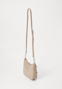 Borsa in pelle beige con una finitura lucida, forma curva, tracolla regolabile e dettagli in metallo argentato. Chiusura con zip nella parte superiore.