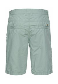 Hellgrüne Shorts aus leichtem Material. Mit flachem Bund, zwei Gesäßtaschen und gestickten Säumen. Minimalistisches Design ohne Muster.