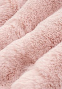 Blødt, fluffy pink stof med en plysset tekstur arrangeret i blide folder, der fremhæver dets hyggelige og varme udseende.