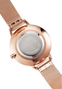 Roségoldene Uhr mit einem Mesh-Armband, ausgestattet mit einem runden Gehäuse und einem Edelstahlboden, der eingravierten Text und Angaben zur japanischen Bewegung zeigt.