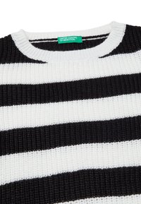 Maglione a righe bianche e nere in tessuto lavorato, con scollo rotondo. Etichetta con la scritta "United Colors of Benetton."