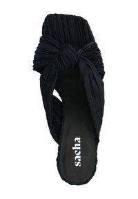Zwarte slipper met geplooide stoffen band met een knoopdetail. Plat voetbed met een gelabelde binnenzool, gladde textuur en open teen ontwerp.