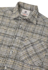 Camisa de cuadros gris y amarillo con botón y un bolsillo, que presenta un cuello tipo polo y una tela texturizada. Etiqueta de GABBANO visible.