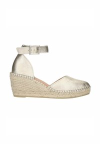 Metallische zilveren espadrille-wedge met een knoopriem. Beschikt over een geweven jute zool en een getextureerde bovenkant, ronde teenontwerp en enkelondersteuning.