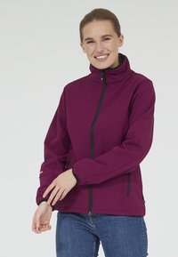 Lila softshell-jacka med hög krage, dragkedja fram och två sidofickor. Har svarta dragkedjor och ärmmuddar för kontrast.