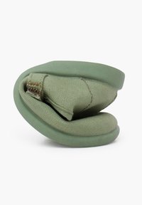 Zapato verde plegable con parte superior de tela y suela de goma, con detalles texturizados y un lazo para facilitar el transporte.