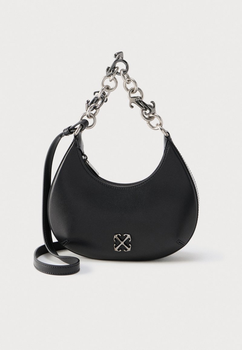 Sac à main noir en forme de croissant avec poignée courte en chaîne argentée et longue bandoulière réglable sur fond blanc.
