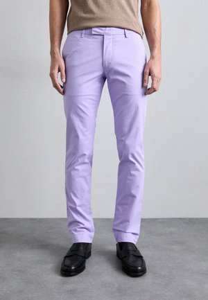 Pantalons en coton violet clair avec une coupe slim et une texture subtile. Design à l'avant plat avec passants de ceinture, assortis à des mocassins noirs.