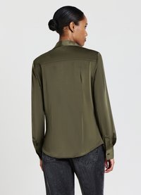 Blusa in satin verde oliva con maniche lunghe, polsini con bottoni e orlo curvo. Presenta una cucitura posteriore per una maggiore struttura.