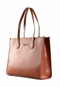 Hnědá kožená taška přes rameno s dvěma dlouhými uchy, která má strukturovaný obdélníkový design a zlaté logo "GUESS" na přední straně.