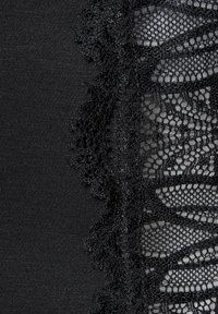 Musthave riidekatte mustriga pitsi ääris, mis näitab peent mustrit sakiliste ääristega ja siledat tekstuuri.