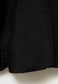 Tissu noir avec une texture lisse et mate. Le matériau tombe doucement sans motifs ni accents distincts visibles.