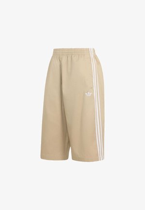 Beiget väriset Adidas-shortsit, joissa joustava vyötärö, kolme valkoista raitaa sivuilla ja pieni valkoinen Adidas-trefoil-logo oikeassa lahkeessa.