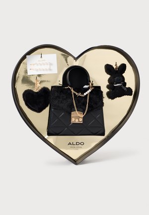 Borsa a tracolla nera trapuntata con dettagli in pelliccia sintetica, accessori in oro e decorazioni a charm. Presentata in una scatola oro a forma di cuore. Include orecchini.