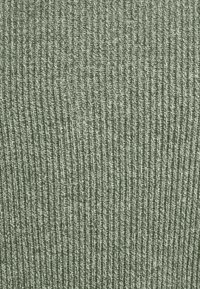 Tissu en maille verte texturée avec des motifs de côtes verticales, présentant une texture douce et lisse ainsi qu'une couleur uniforme et atténuée sur toute la surface.