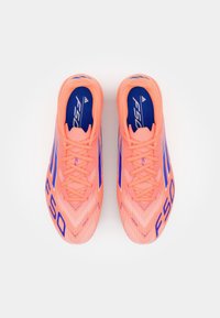 Scarpe da calcio di un vivace colore rosa brillante, dotate di una tomaia testurizzata, accenti blu e un audace marchio "F50". Progettate con una forma slanciata e aerodinamica.